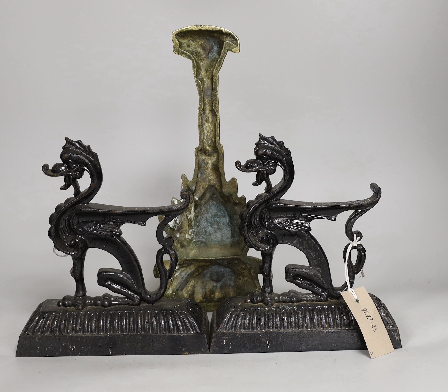 A pair of cast iron seated lion dog doorstops, together with A brass pineapple shaped door porter. Tallest 31cm